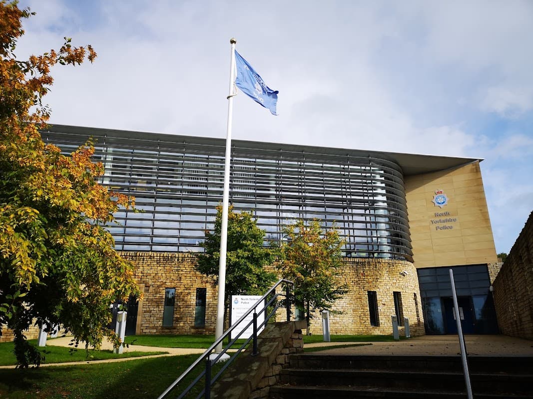North Yorkshire Police building in Harrogate, featuring a flag, modern architecture, and landscaped surroundings.