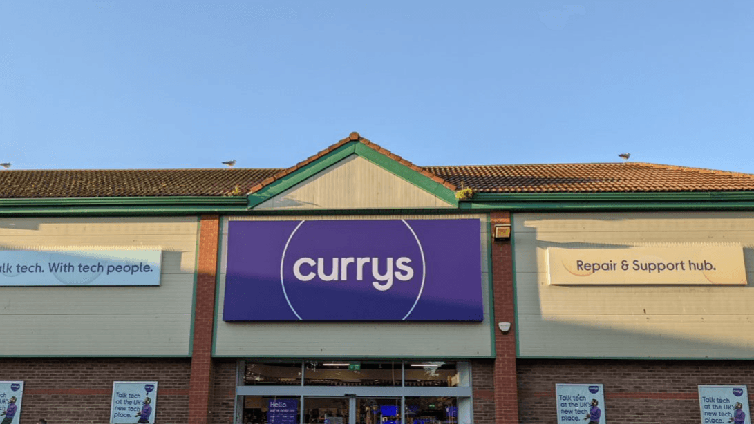 Currys store exterior in Bessingby, Yorkshire, featuring a large sign and banners for tech support and repair services.