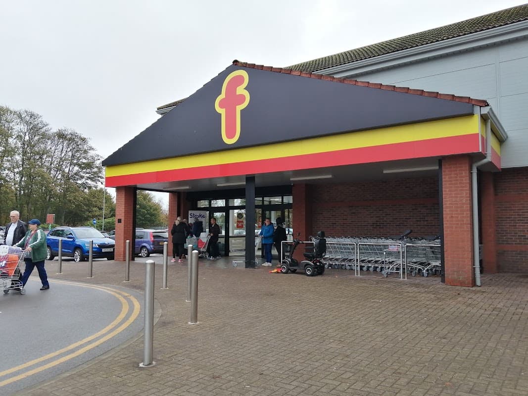 Farmfoods Ltd shop entrance with yellow and red signage, shopping trolleys, and customers outside in Bessingby, Yorkshire.