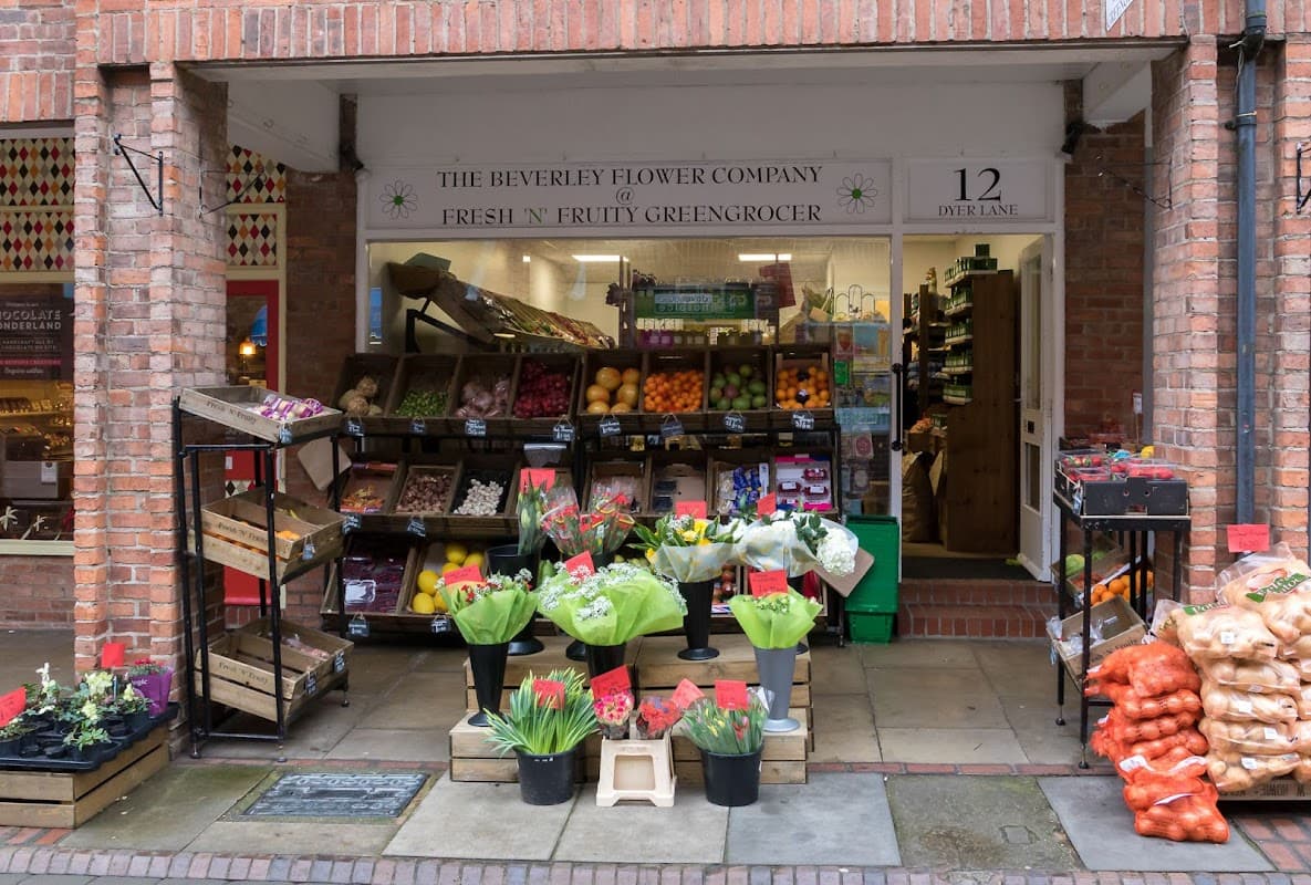 Colorful display of fruits, vegetables, and flowers outside a shop with a welcoming entrance in Beverley, Yorkshire.