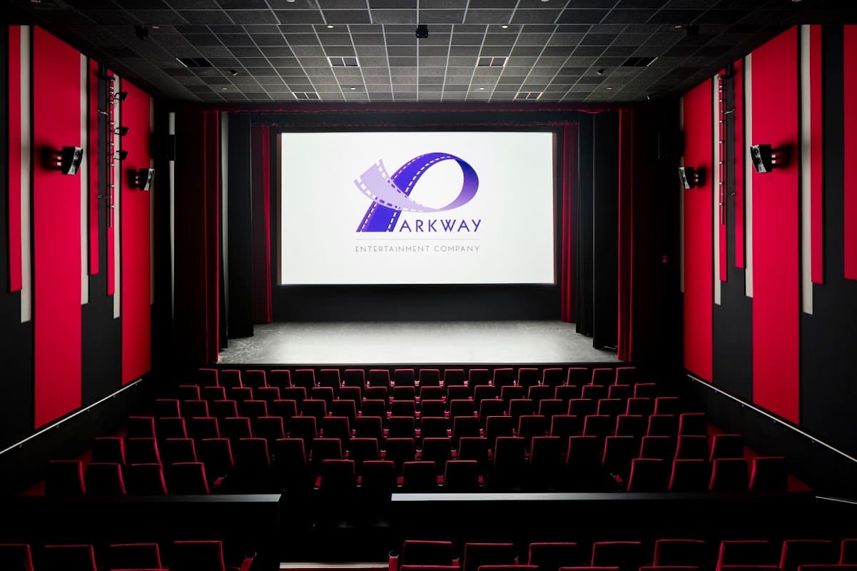 Interior of Parkway Cinema Beverley featuring red and black decor, a large screen, and rows of empty red seats.