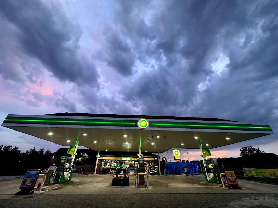 Bilbrough Top Services with a BP petrol station under a cloudy sky, featuring fuel pumps and a shop entrance.