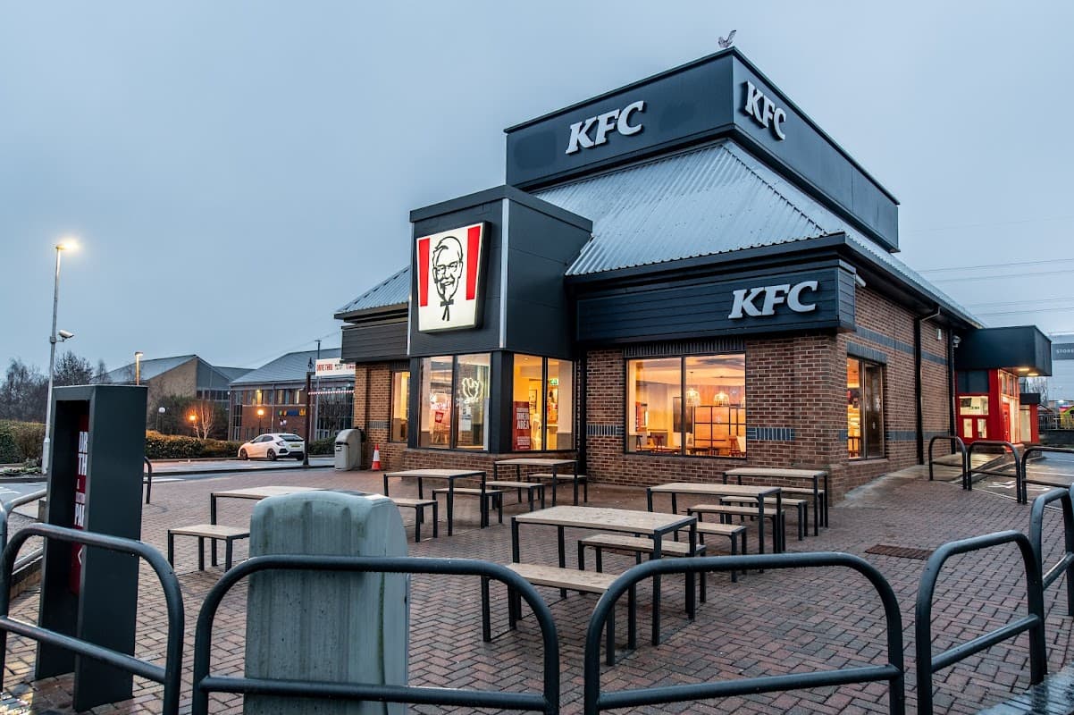 KFC restaurant with outdoor seating, illuminated signage, and a modern design in Birstall, Yorkshire.