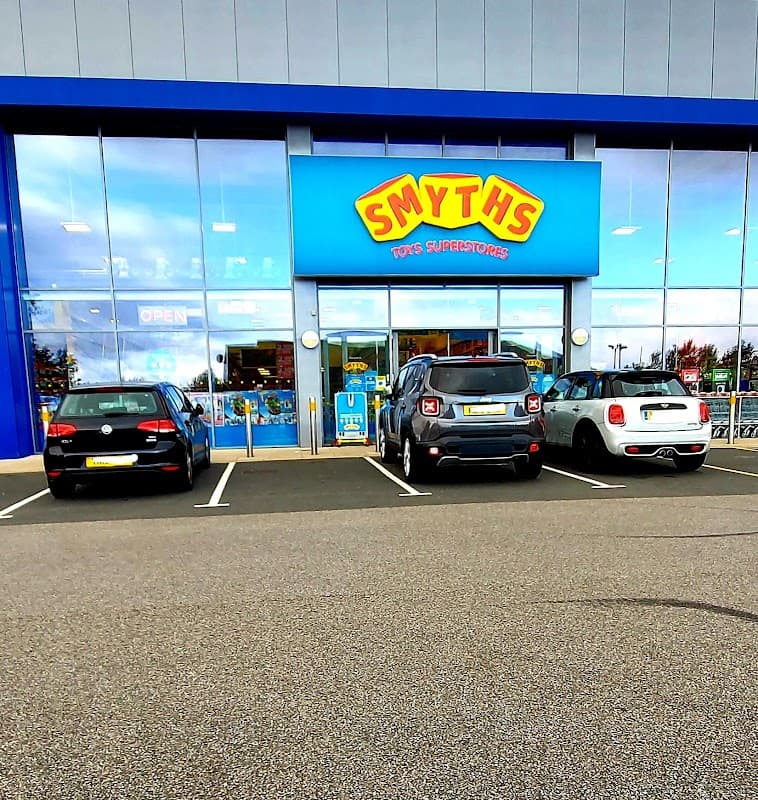 Smyths Toys Superstores storefront with large blue sign, three parked cars, and bright, inviting entrance.