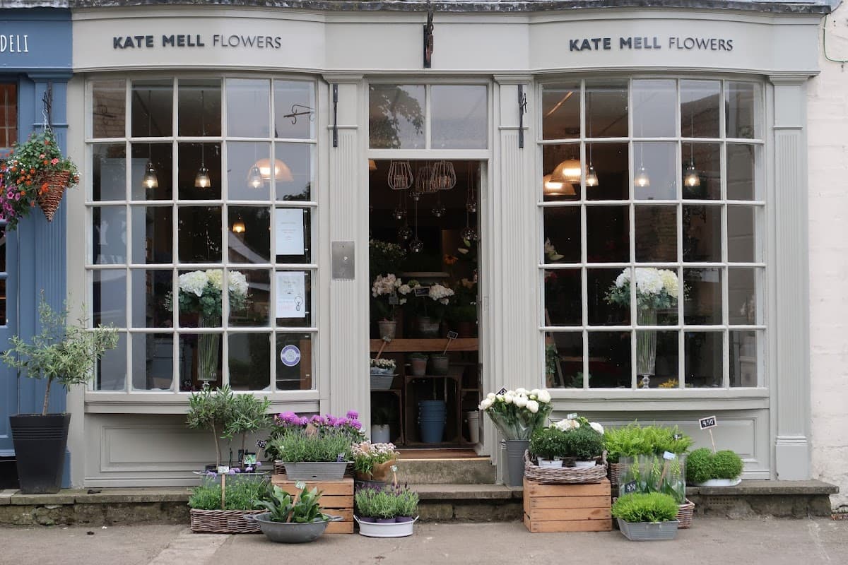Charming flower shop with large windows, planters of flowers, and greenery outside, located in Boston Spa, Yorkshire.