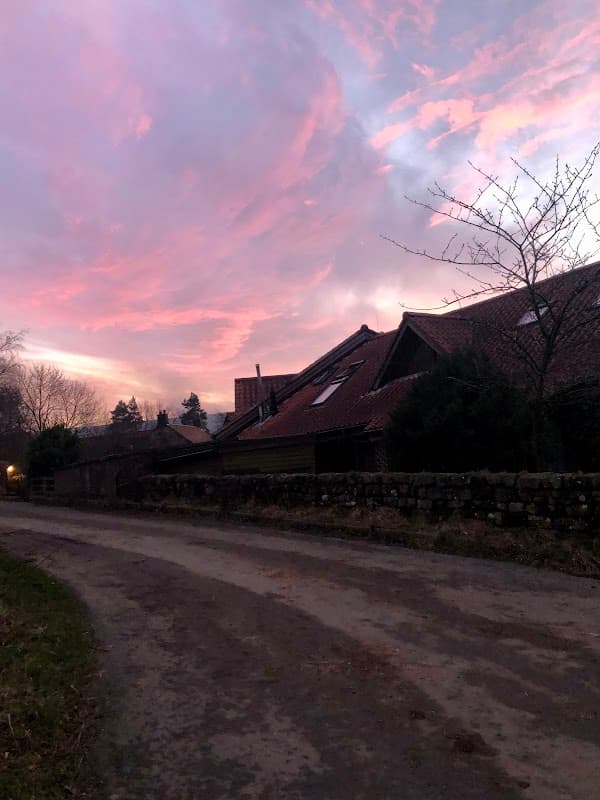 Charming village store with a rustic building against a vibrant sunset sky in Botton, North Yorkshire.