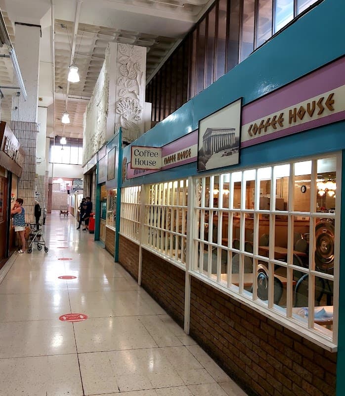 Interior view of Kirkgate Shopping Centre featuring shops, coffee house signage, and shoppers in a spacious hallway.