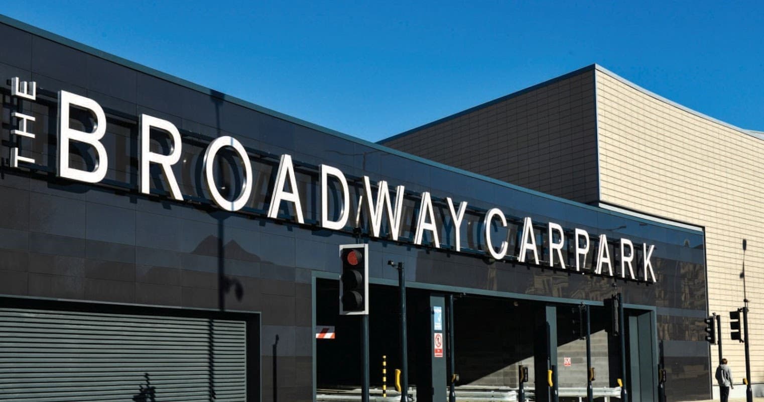 The Broadway Car Park building with large signage, modern architecture, and clear blue sky above.