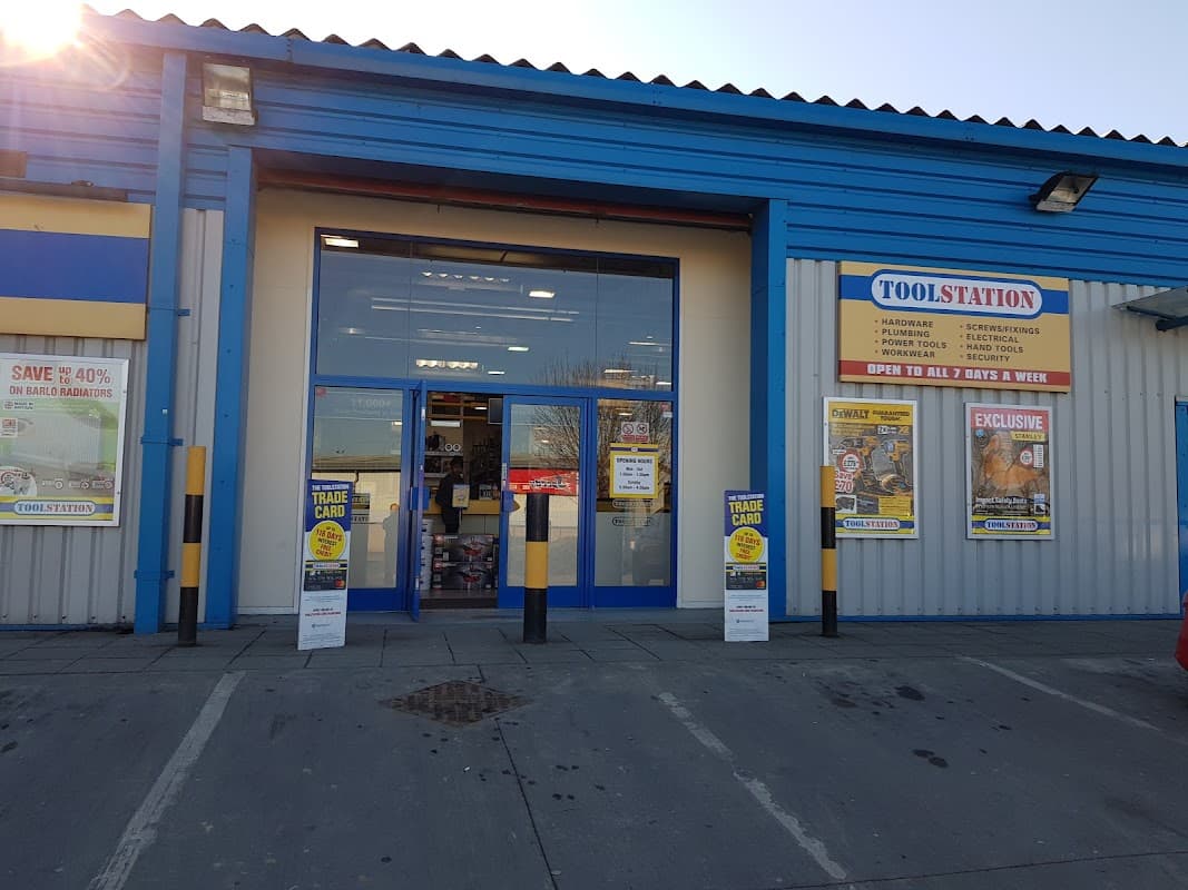 Bright blue building with large glass entrance, promotional signs, and trade card advertisements outside Toolstation Bradford.