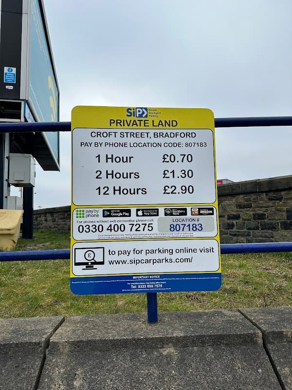 Sign for Vicar Lane Car Park detailing parking rates: 1 hour £0.70, 2 hours £1.30, 12 hours £2.30, located in Bradford.