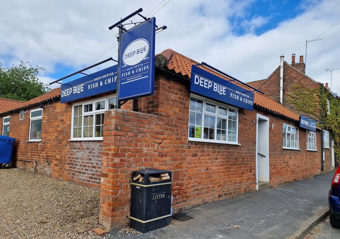 Deep Blue Fish & Chips restaurant with brick exterior, blue signage, and a litter bin outside, set in Brandesburton, Yorkshire.