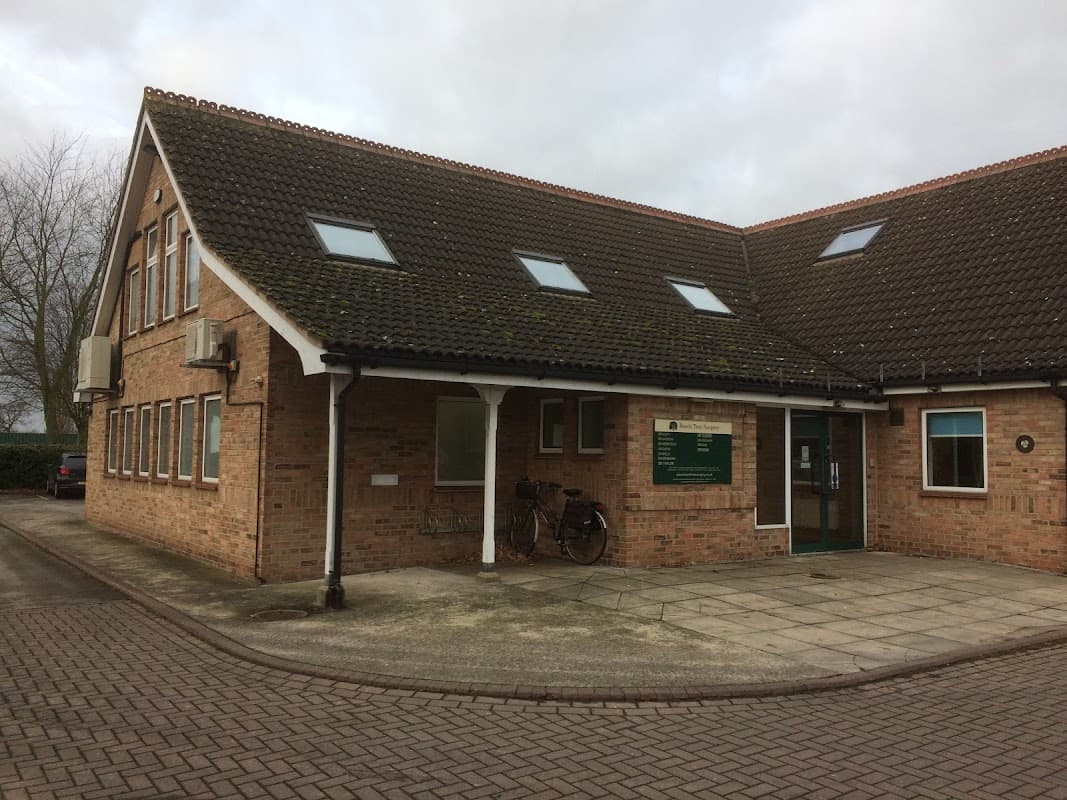 Brick building with a sloped roof, windows, sign for Beech Tree Surgery, and a bicycle outside in Brayton, North Yorkshire.