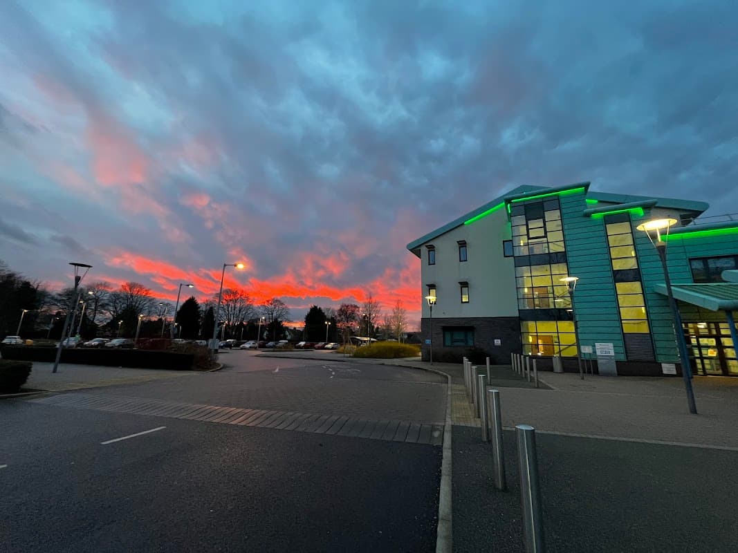 Selby War Memorial Hospital building with green accents, under a vibrant sunset sky and cloudy conditions.