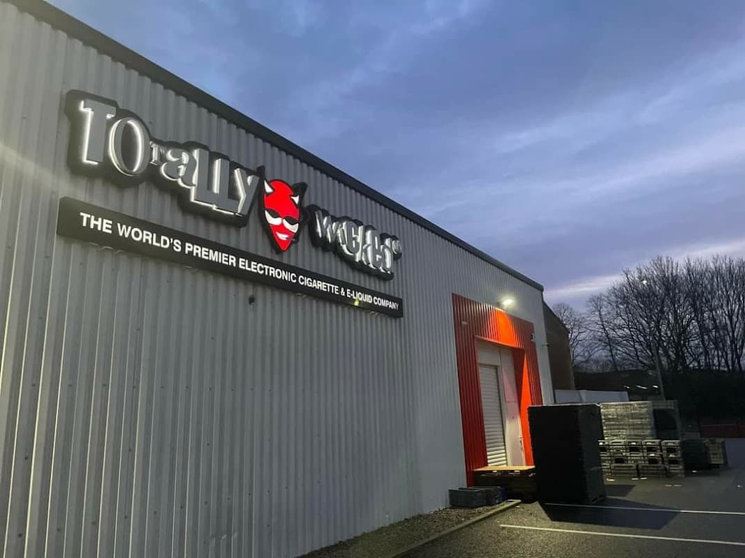 Signage for "Totally Wicked" with a red and white exterior, set against a twilight sky in Brighouse, Yorkshire.