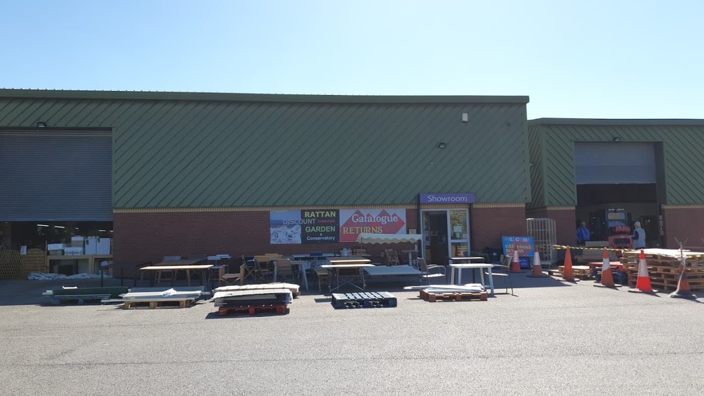 Exterior of Catalogue Returns Ltd in Brotherton, featuring a showroom entrance and pallets outside. Clear blue sky.