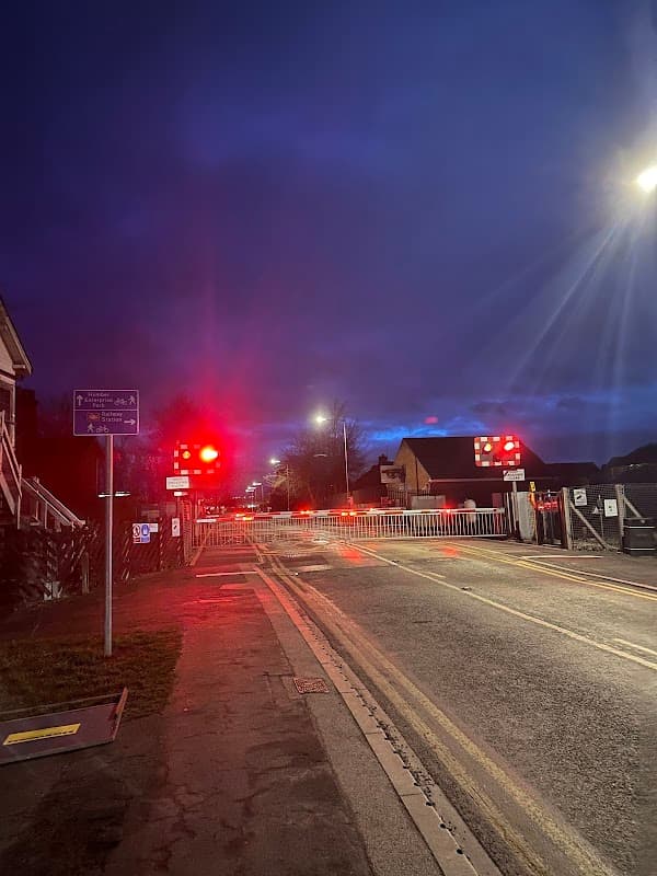Brough Station Long Stay Car Park entrance at night, with red signal lights and a barrier across the road.