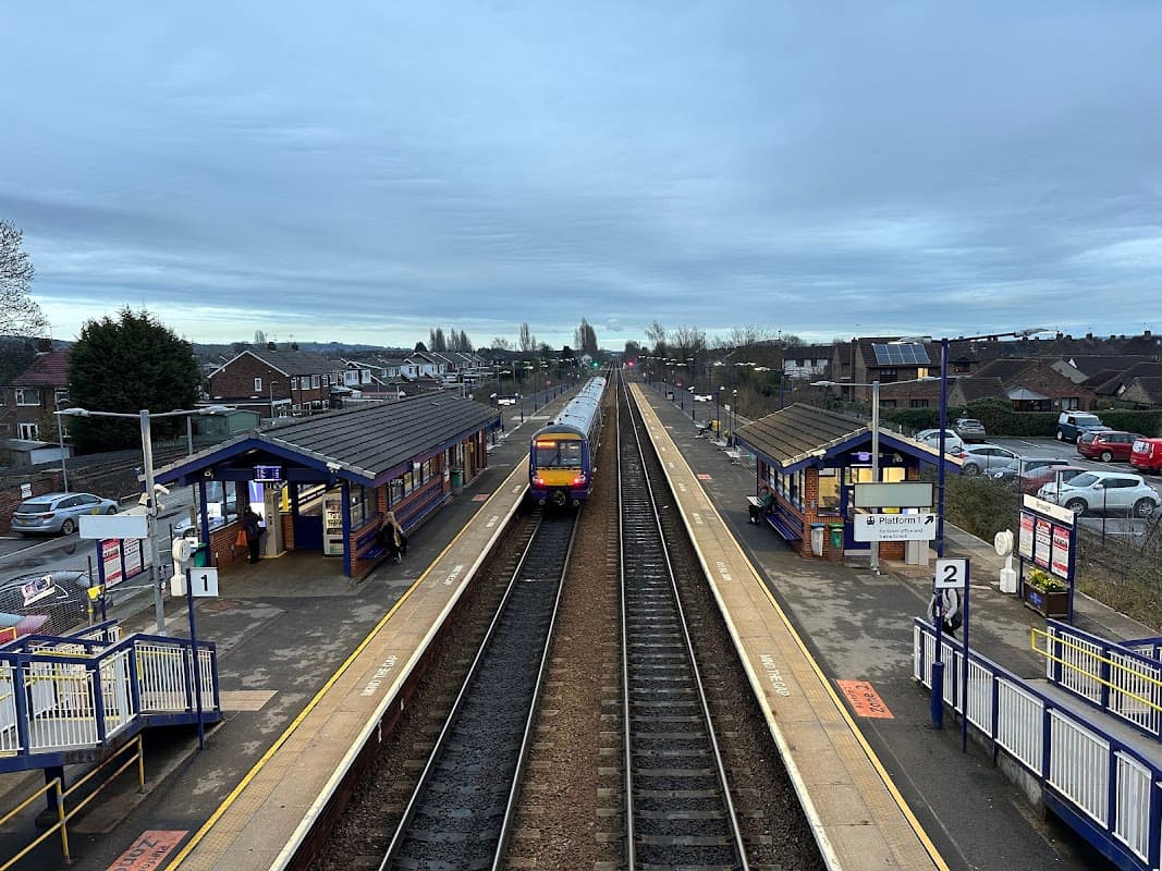 Brough Station with two platforms, a train approaching, and a Pay & Display car park in the background.