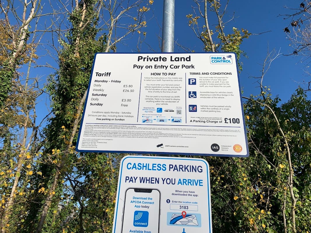 Sign detailing parking tariffs, payment methods, and terms for Skillings Lane car park in Brough, surrounded by trees.