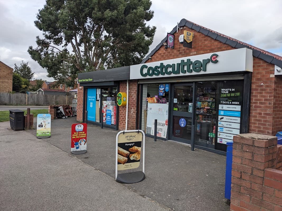 Costcutter storefront with large windows displaying products, signage, and promotional boards outside.