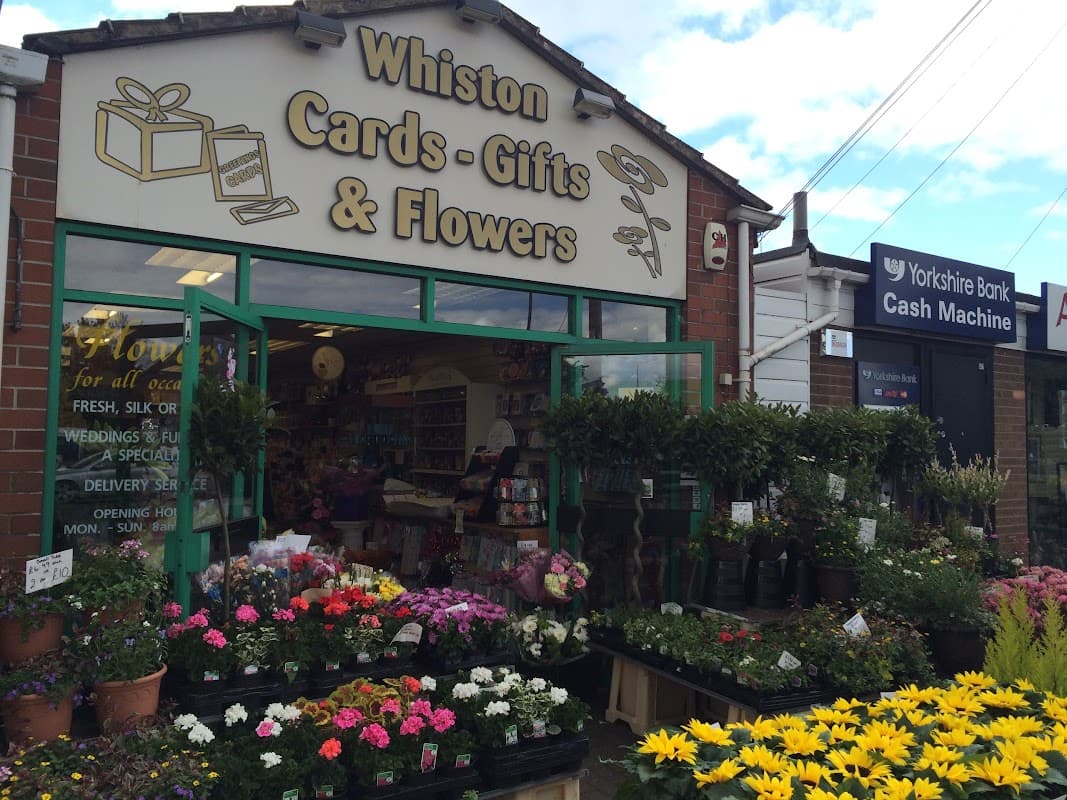 Brightly colored flowers and plants outside a shop with a sign reading "Whiston Cards Gifts & Flowers" in Canklow, Yorkshire.