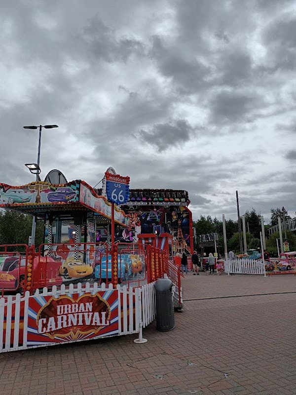 Colorful carnival rides and stalls with a cloudy sky in the background at Junction 32 Shopping Outlet Car Park.