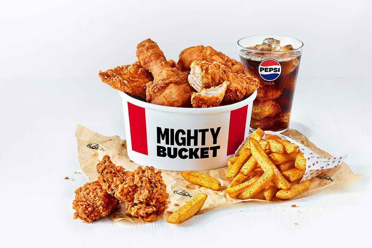 Mighty Bucket filled with fried chicken, fries, and a glass of Pepsi on a white background.