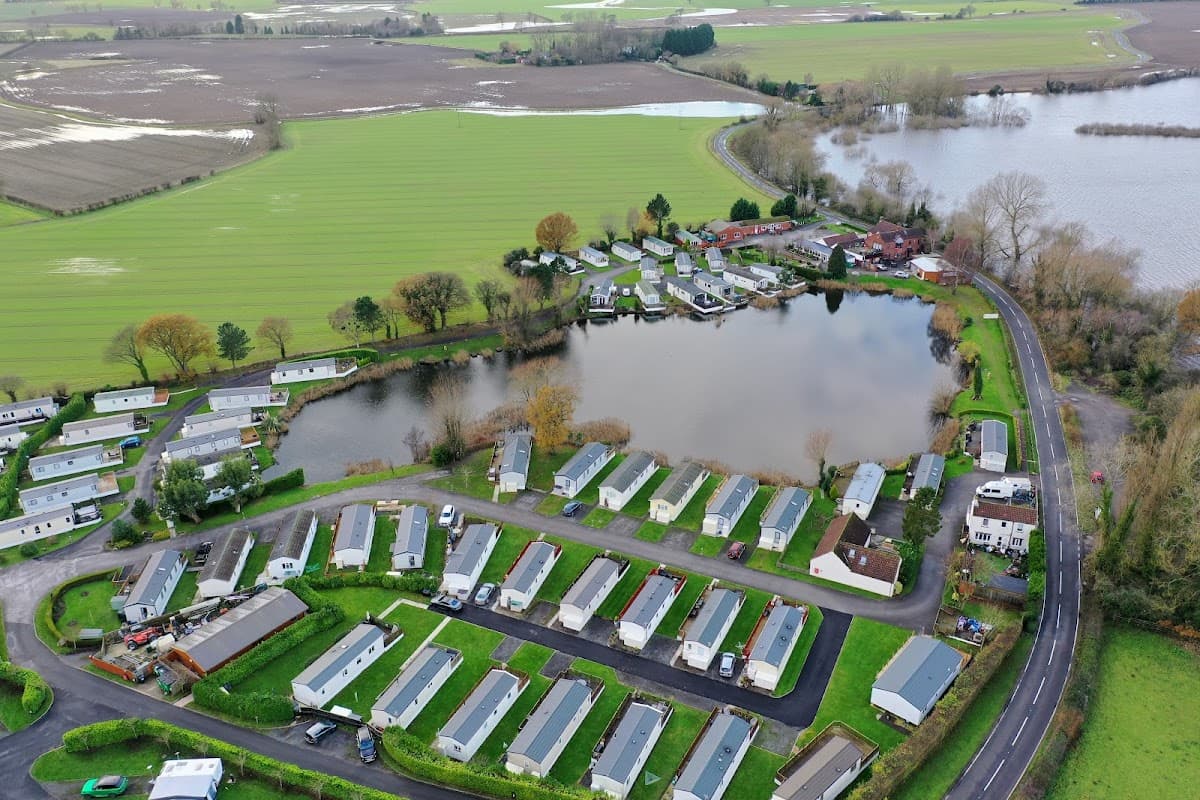 Aerial view of White Cross Ski Club with mobile homes, a lake, and surrounding green fields in Cawood, Yorkshire.