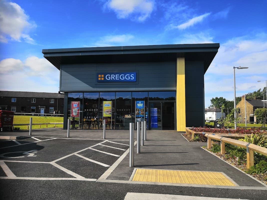 Greggs shop in Clayton, Yorkshire, featuring a modern facade, signage, and outdoor seating area.