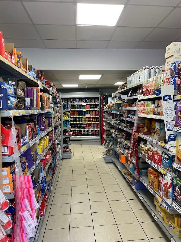 Aisles filled with various products, including snacks, drinks, and household items in a Tesco Express store.