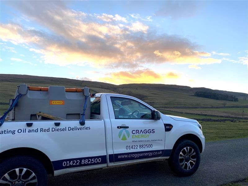 Craggs Energy Ltd truck parked on a rural road with a scenic sunset and hills in the background.