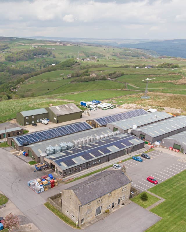 Vocation Brewery with solar panels, surrounded by green hills and parking area in Cragg Vale, Yorkshire.