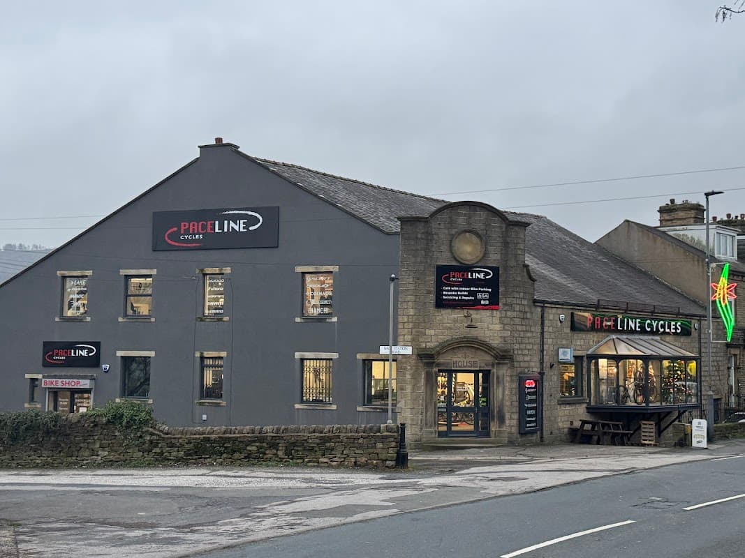 Paceline Cycles shopfront featuring a bike shop and café, with signage and a large window display in Cross Hills, Yorkshire.