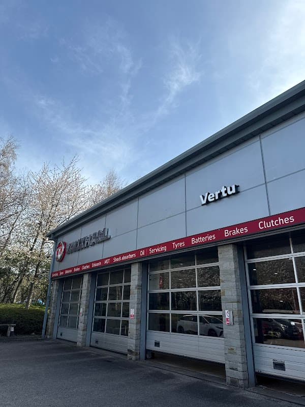 Vertu Vauxhall shop exterior in Cross Hills, Yorkshire, featuring service bays and signage under a clear blue sky.