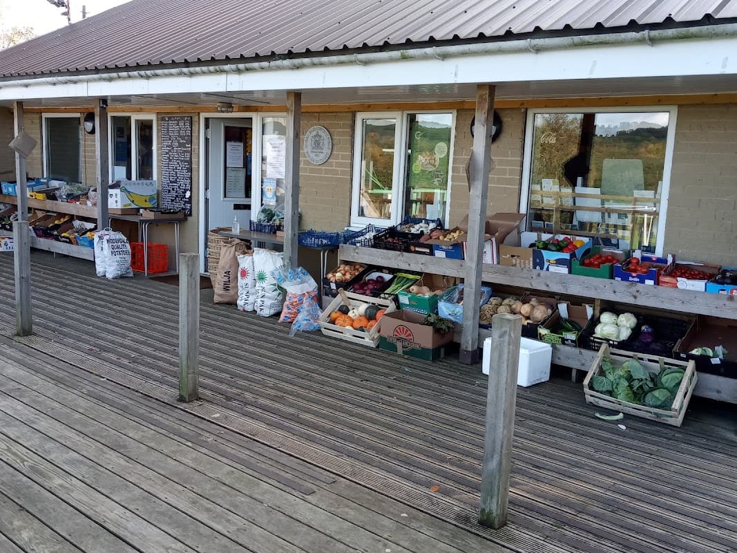 Darley Post Office features a wooden deck with fresh produce displayed in crates and bags outside the entrance.