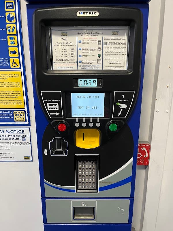 Parking payment machine displaying time, date, and "NOT IN USE" message, with various payment options and instructions.