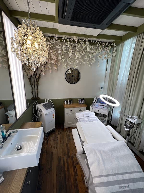 Elegant treatment room with a chandelier, modern equipment, and a relaxing ambiance featuring floral decor.