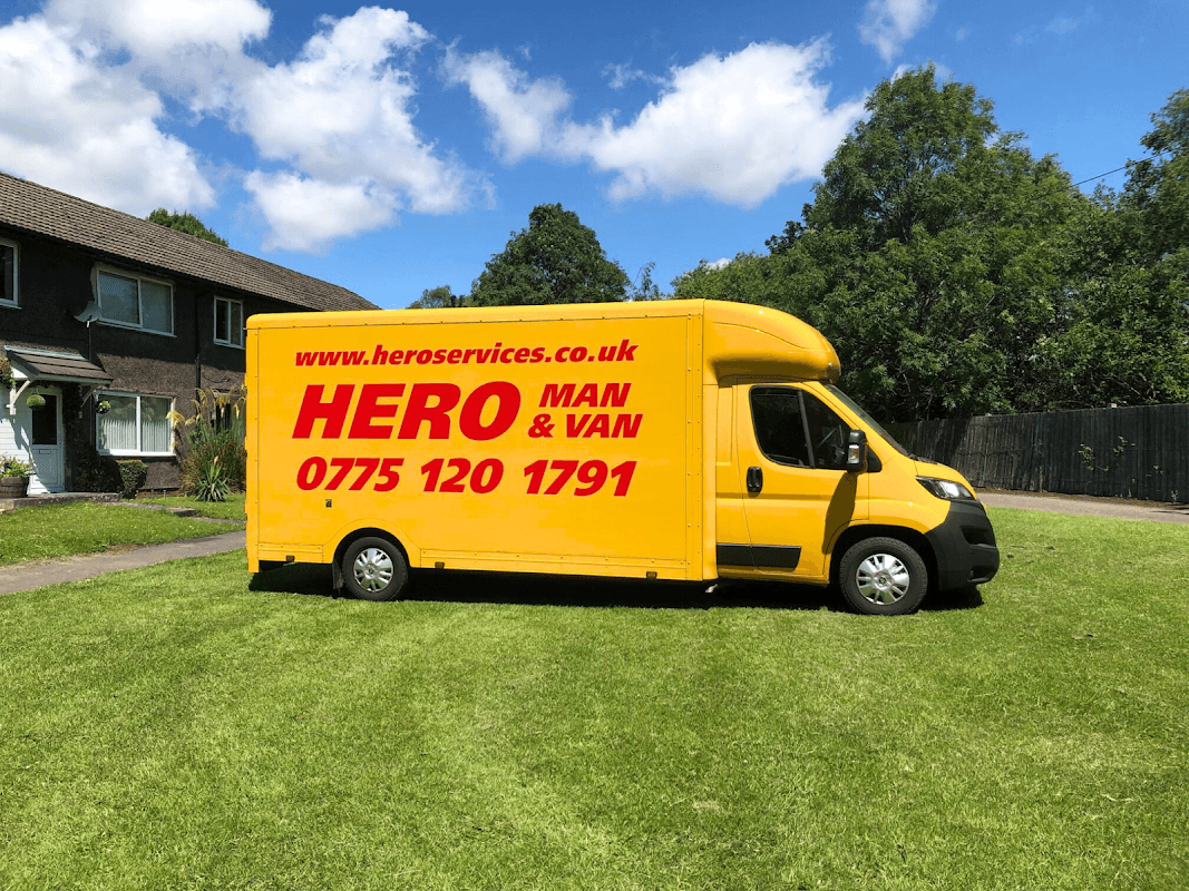 Bright yellow van with "HERO MAN & VAN" and contact details parked on green grass in Deepcar, Yorkshire.