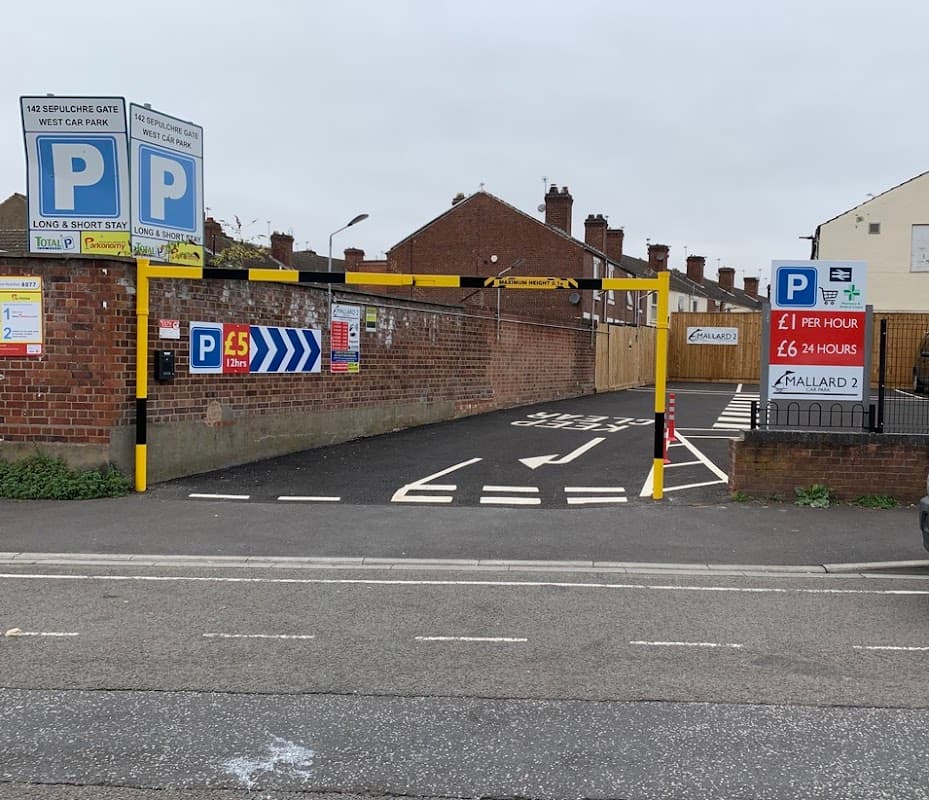 Entrance to Mallard 2 Car Park with pay signs, marked lanes, and brick wall backdrop in Doncaster, Yorkshire.