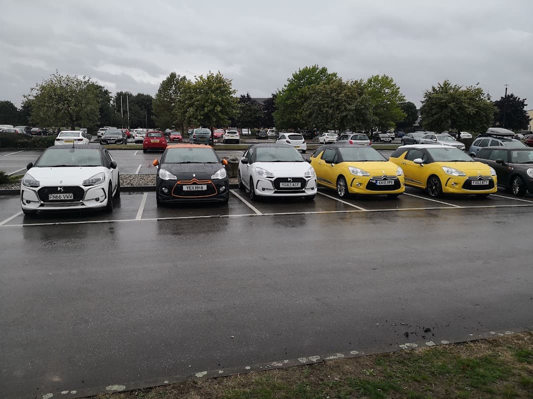 Free parking area in Doncaster, Yorkshire, with several parked cars under a cloudy sky.