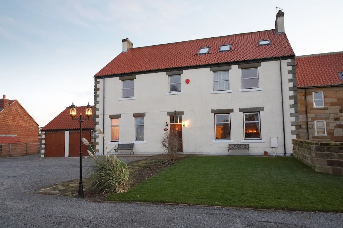 Townend Farm Bed & Breakfast, a two-story building with a red roof, surrounded by grass and a lantern in Easington, Yorkshire.