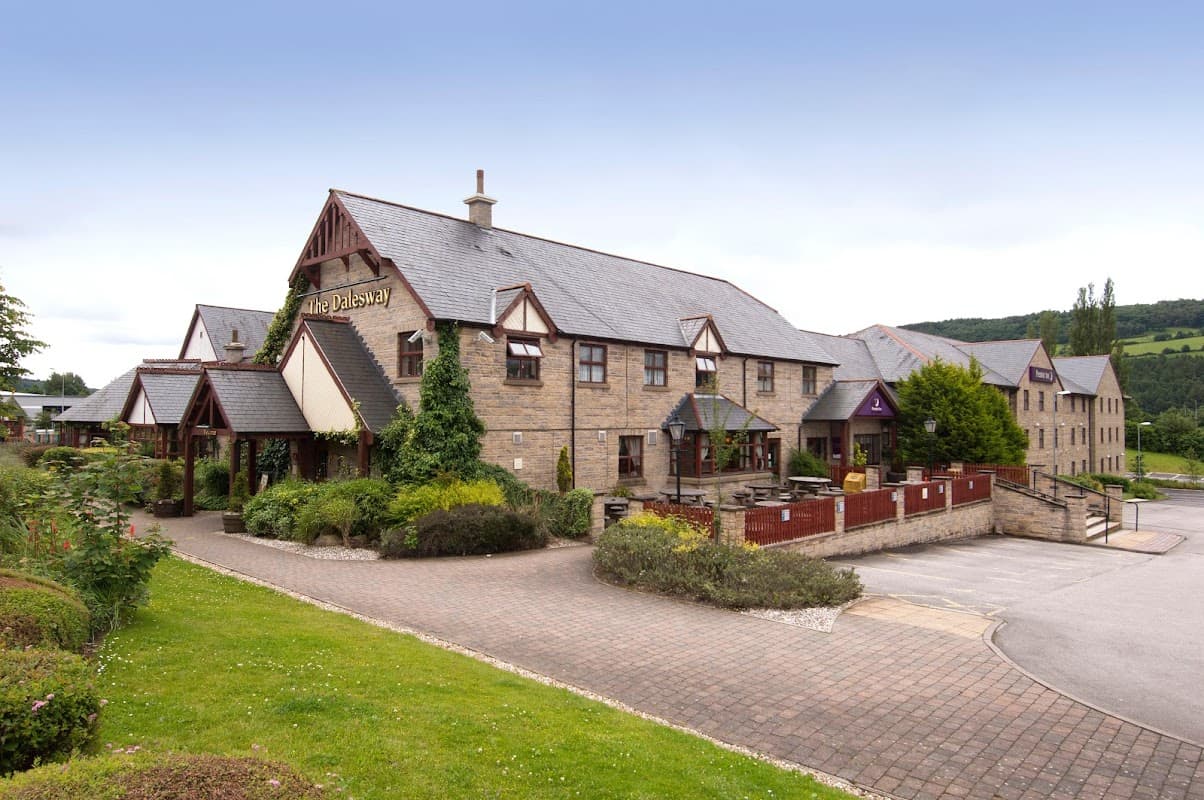 Premier Inn Bradford North hotel features a stone exterior, landscaped gardens, and a parking area in a scenic setting.