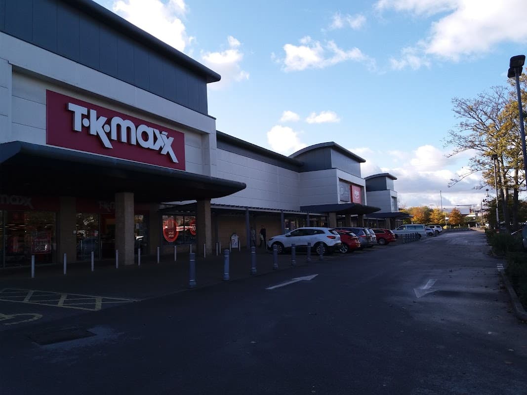 TK Maxx storefront with a parking area, blue sky, and scattered clouds in Eckington, Yorkshire.