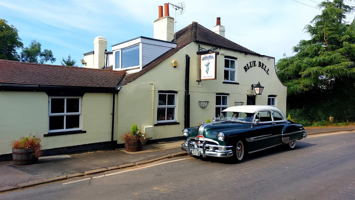 Historic Blue Bell Inn with a classic car parked outside, surrounded by greenery in Ellerby, Yorkshire.
