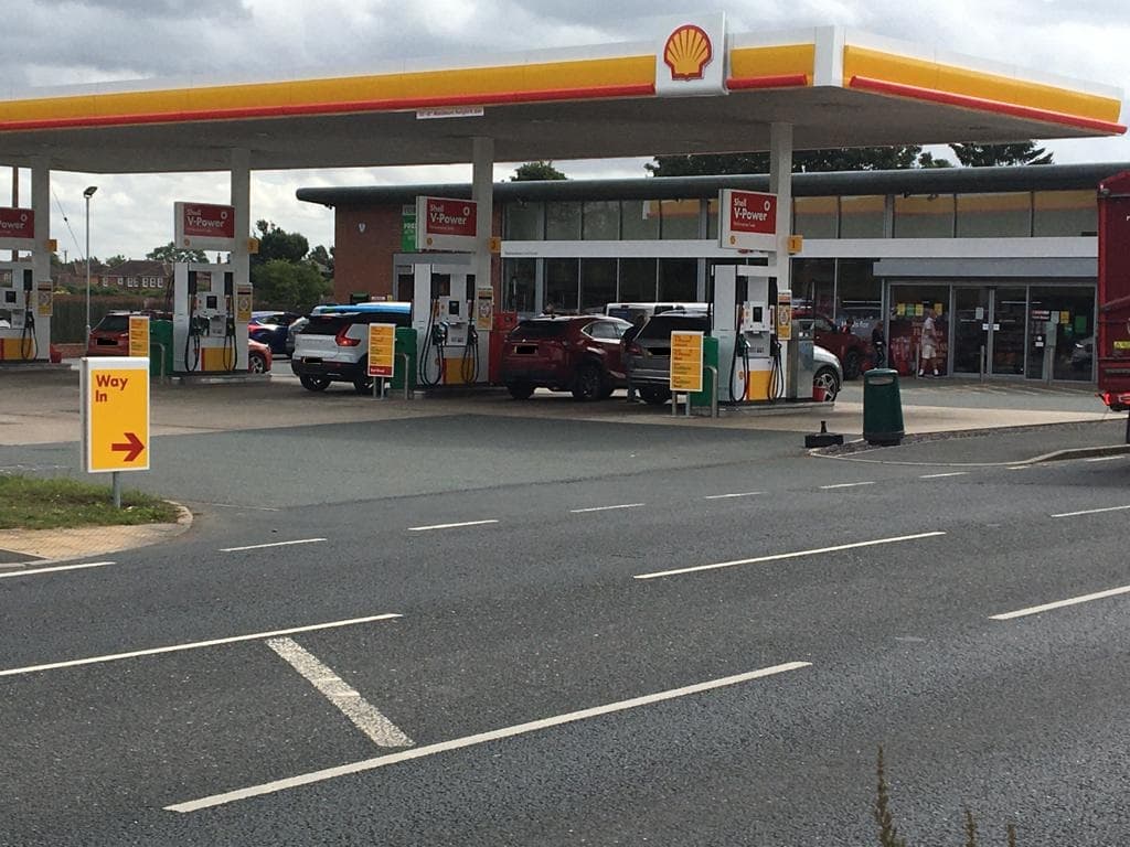 York Road Garage in Escrick, featuring a Shell station with fuel pumps, cars, and a convenience store.