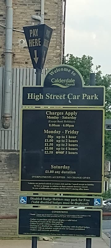 Sign for High Street Car Park in Exley, Yorkshire, detailing parking charges and conditions for different days.