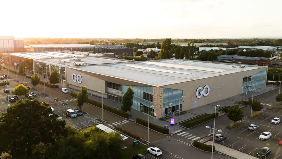 GO Outdoors store in Farsley, Yorkshire, with large signage and parking lot filled with cars under a sunset sky.