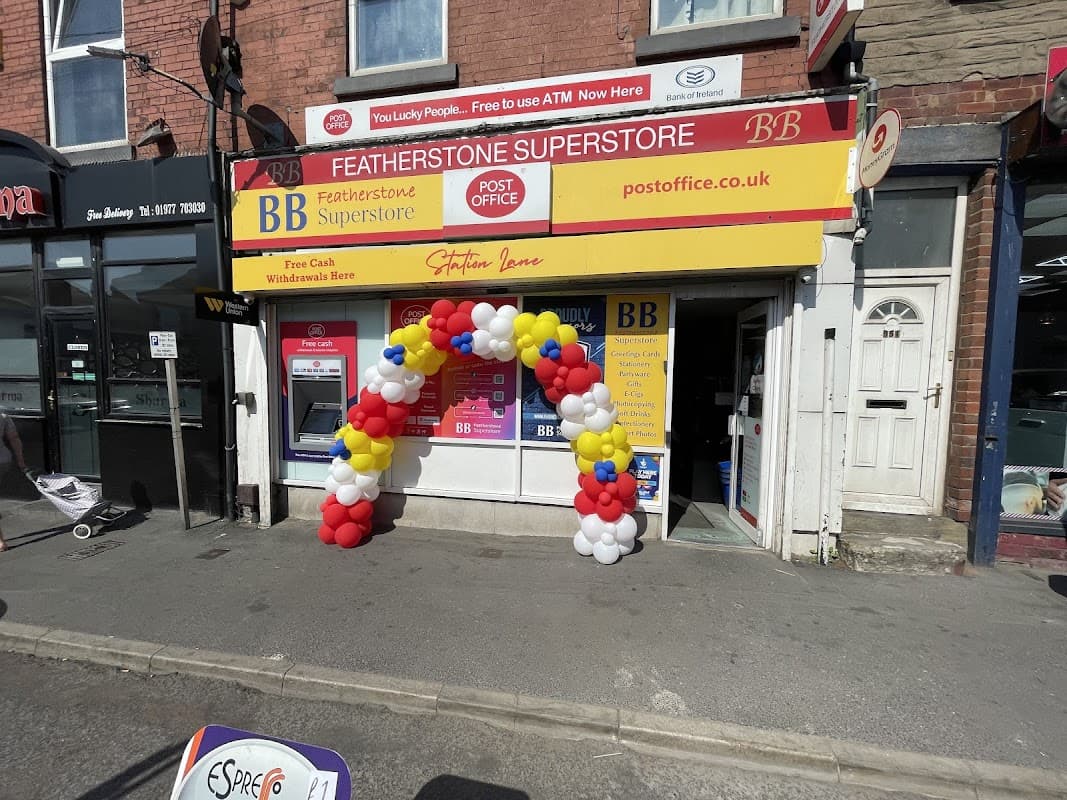 Featherstone Post Office with a colorful balloon arch at the entrance and a bright red and yellow sign above.