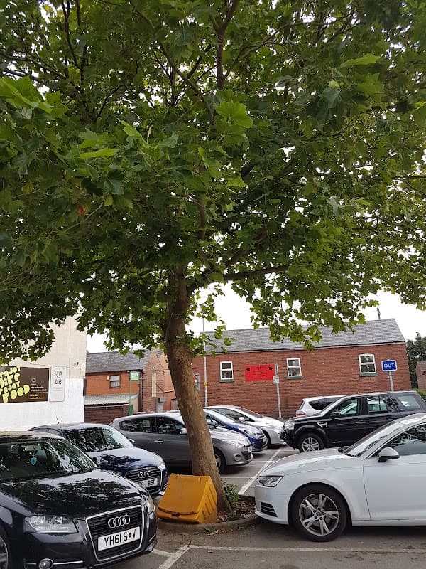 Main Street Car Park in Garforth, featuring parked cars, a tree, and nearby buildings with a "Free Parking" sign.