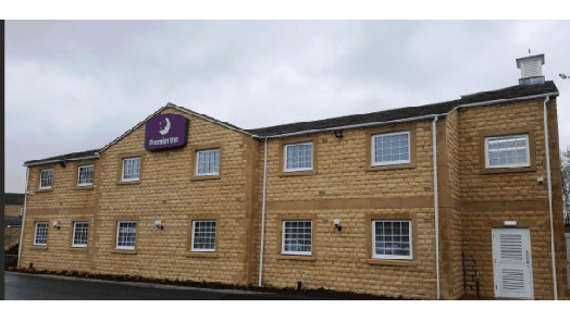 Premier Inn building with a stone facade and multiple windows, set against a cloudy sky in Gargrave, Yorkshire.