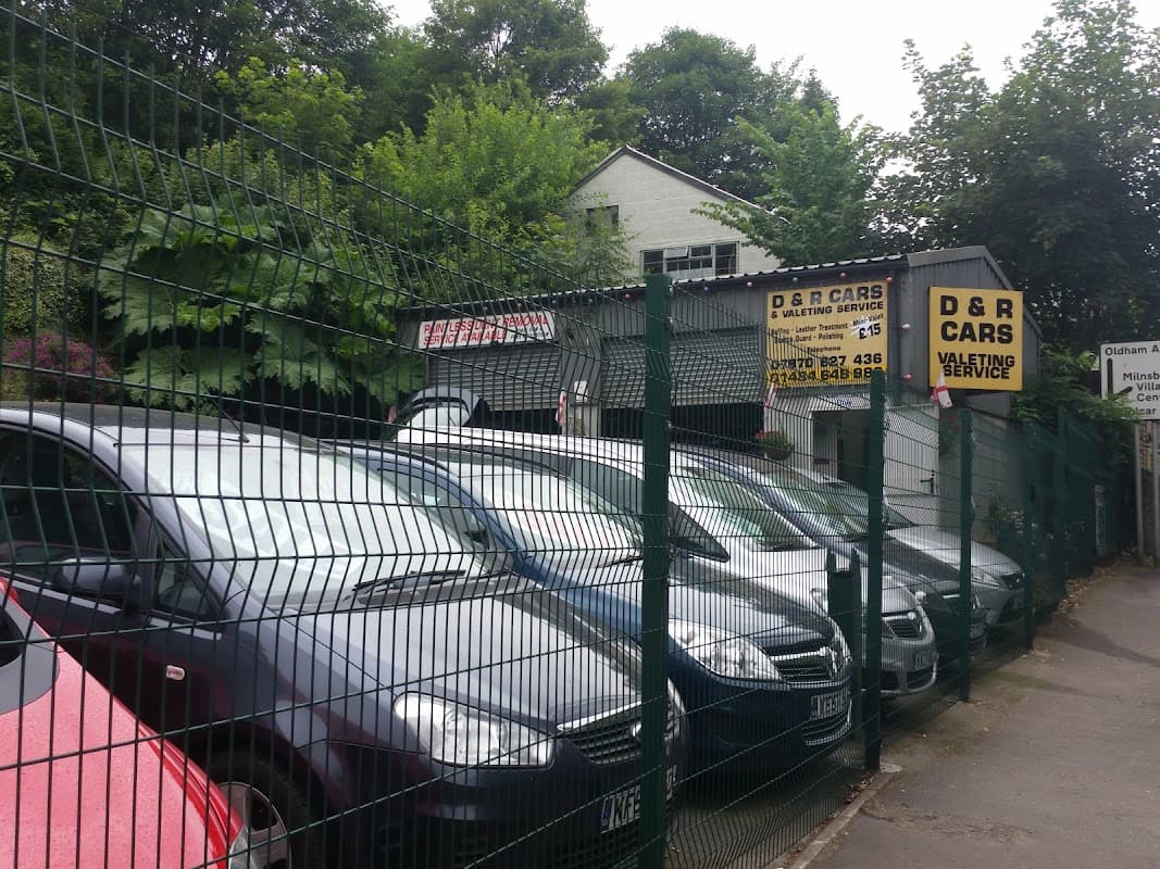 D & R Cars car park with several parked vehicles and signage, surrounded by greenery in Golcar, Yorkshire.